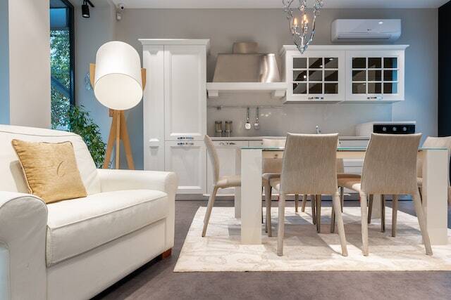 white dining room with a glass table and white linen chairs